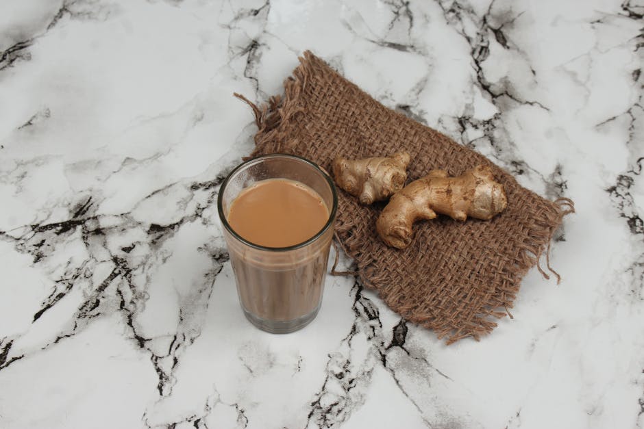 Bicchiere di masala chai indiano con zenzero fresco su marmo