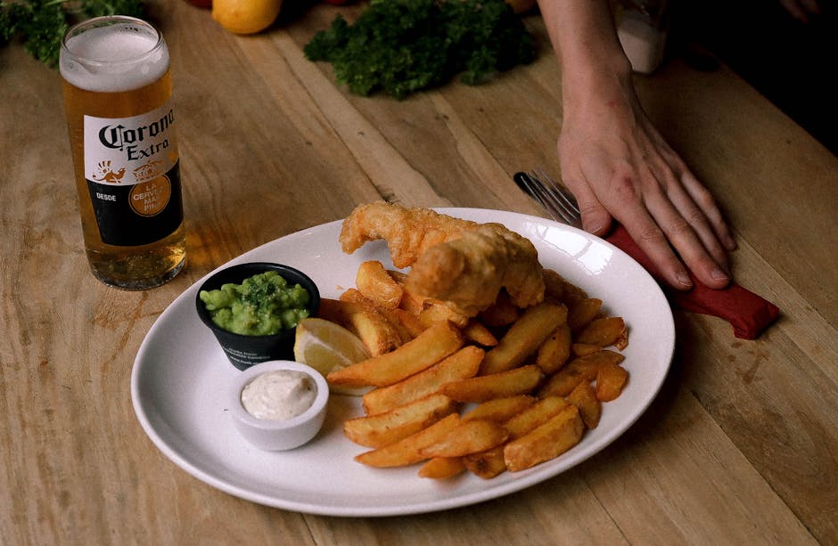 Fish and chips con birra serviti su un tavolo di legno